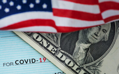 A close-up image reveals part of an American flag, a one-dollar bill, and a check with the text